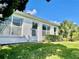 Low angle view of a white one-story home with large windows and green lawn at 1312 Corona Ave, The Villages, FL 32159
