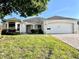 Charming single-story home with a well-manicured lawn, a brick driveway and mature landscaping at 1312 Corona Ave, The Villages, FL 32159