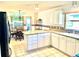 Bright kitchen with tile floors, granite countertops, white cabinets, and breakfast nook at 1312 Corona Ave, The Villages, FL 32159