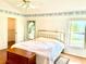 Comfortable main bedroom with wood floors, ceiling fan, two windows and a view of the walk-in closet at 1312 Corona Ave, The Villages, FL 32159