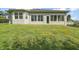 Expansive backyard featuring a well-manicured lawn and a sunroom with large windows that offer ample natural light at 137 E Palmetto Ave, Howey In The Hills, FL 34737