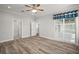 Spacious bedroom with wood-look floors, ceiling fan, and access to the lanai at 137 E Palmetto Ave, Howey In The Hills, FL 34737