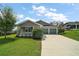 Charming home featuring a two-car garage, well-maintained lawn, and tasteful landscaping for enhanced curb appeal at 137 E Palmetto Ave, Howey In The Hills, FL 34737