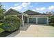 Charming home featuring gray siding, a spacious driveway, and a well-kept lawn and shrubbery at 137 E Palmetto Ave, Howey In The Hills, FL 34737