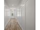 Hallway featuring wood-look flooring and white paneled walls, leading to the front door at 137 E Palmetto Ave, Howey In The Hills, FL 34737