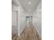Bright hallway with decorative paneling and wood-look flooring leading to the rest of the home at 137 E Palmetto Ave, Howey In The Hills, FL 34737