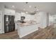 Modern kitchen featuring white cabinets, stainless steel appliances, and a granite-topped island at 137 E Palmetto Ave, Howey In The Hills, FL 34737