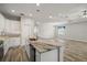 Open-concept kitchen with white cabinetry, stainless steel appliances, and a clear view into the living room at 137 E Palmetto Ave, Howey In The Hills, FL 34737