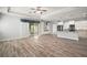 Open-concept living room flowing into kitchen, featuring wood-look floors and sliding glass doors at 137 E Palmetto Ave, Howey In The Hills, FL 34737