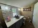 Bright bathroom featuring decorative stone wall accents, modern sink, toilet, and storage shelves at 1425 Douglas Rd, Groveland, FL 34736