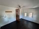 A bright bedroom featuring original wood floors, a ceiling fan, and good natural light at 1425 Douglas Rd, Groveland, FL 34736