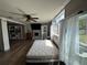Comfortable bedroom featuring hardwood floors, ceiling fan, and a window with sheer curtains for soft, natural light at 1425 Douglas Rd, Groveland, FL 34736