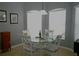 Cozy dining area with a glass table, comfortable chairs, and bright natural light from the window at 146 Essex Pl, Davenport, FL 33896
