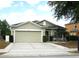 Charming single-story home featuring a two-car garage, well-manicured lawn, and neutral-colored exterior at 146 Essex Pl, Davenport, FL 33896