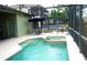 Outdoor screened-in pool area with a spa, patio furniture, and an umbrella for shaded relaxation by the pool at 146 Essex Pl, Davenport, FL 33896