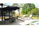 Outdoor pool area with patio furniture under an umbrella and an in-ground spa, all enclosed in a screen at 146 Essex Pl, Davenport, FL 33896