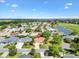 Overhead neighborhood shot showcasing home's proximity to the golf course, landscaping, and curb appeal at 1561 Loris Loop, The Villages, FL 32162