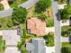 Aerial view of a well-manicured house featuring a brown roof, screened in patio, landscaping and beautiful driveway at 1561 Loris Loop, The Villages, FL 32162
