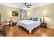 Comfortable bedroom featuring hardwood floors, ceiling fan, and natural light at 1561 Loris Loop, The Villages, FL 32162