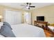 This bedroom features hardwood floors, a ceiling fan, and lots of natural light at 1561 Loris Loop, The Villages, FL 32162