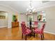Dining area with hardwood floors, decorative chairs, and an open view into the kitchen at 1561 Loris Loop, The Villages, FL 32162