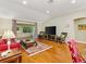 Bright living room with hardwood floors, vaulted ceilings, and comfortable seating at 1561 Loris Loop, The Villages, FL 32162