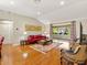 Inviting living room featuring hardwood floors, a vaulted ceiling, and sunroom access at 1561 Loris Loop, The Villages, FL 32162