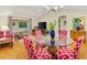 Open living room with hardwood floors, dining table, and access to the lanai at 1561 Loris Loop, The Villages, FL 32162