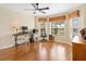 Inviting home office with hardwood floors, large bay window, and ceiling fan, perfect for working remotely at 1561 Loris Loop, The Villages, FL 32162