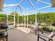 Relaxing screened patio with comfortable seating surrounded by lush greenery, perfect for outdoor enjoyment at 1561 Loris Loop, The Villages, FL 32162