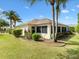 Well-maintained backyard with lush green lawn, mature landscaping and a screened lanai at 1561 Loris Loop, The Villages, FL 32162