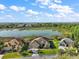 Aerial view of a beautiful home by a lake, highlighting its manicured lawn at 1723 Carrera Dr, The Villages, FL 32159