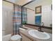 Bathroom featuring a vanity with a granite countertop, framed mirror, and bathtub with shower at 1723 Carrera Dr, The Villages, FL 32159