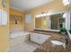 Bright bathroom features a soaking tub, double sinks and white cabinetry at 1723 Carrera Dr, The Villages, FL 32159