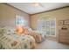 Cozy bedroom with twin beds, tiled floor, ceiling fan, and window with plantation shutters at 1723 Carrera Dr, The Villages, FL 32159