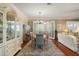 Dining room with hardwood floors, elegant lighting, glass display cabinet, and seating for six people at 1723 Carrera Dr, The Villages, FL 32159