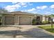 Charming home featuring a three-car garage and well-maintained landscaping and a sidewalk at 1723 Carrera Dr, The Villages, FL 32159