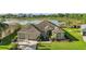 An attractive home features a three-car garage, mature landscaping, and is situated on a picturesque lot with water views at 1723 Carrera Dr, The Villages, FL 32159