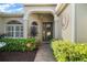 Inviting entrance with stone walkway, lush landscaping, decorative windows, and sunburst wall art accents at 1723 Carrera Dr, The Villages, FL 32159