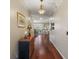 Long hallway with hardwood floors, decorative lighting and wall art leading to the dining room and living room at 1723 Carrera Dr, The Villages, FL 32159