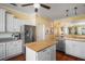 Bright eat-in kitchen featuring white cabinetry, stainless appliances and wood flooring at 1723 Carrera Dr, The Villages, FL 32159