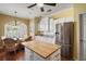 Bright kitchen featuring white cabinetry, stainless appliances and a dining area at 1723 Carrera Dr, The Villages, FL 32159