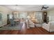Spacious living room with hardwood floors, plantation shutters, comfortable seating, and adjacent dining area at 1723 Carrera Dr, The Villages, FL 32159