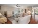 Bright living room featuring hardwood floors, built-in shelving, a ceiling fan and comfortable couches at 1723 Carrera Dr, The Villages, FL 32159