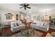 Open-concept living room with wood floors and comfortable seating connects seamlessly to the dining area at 1723 Carrera Dr, The Villages, FL 32159