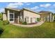 Image showcasing a home's exterior, featuring a screened-in patio and lush green lawn at 1723 Carrera Dr, The Villages, FL 32159