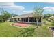 Charming backyard with a brick patio, large green lawn, screened patio and privacy fence at 179 Patrice Hope St, Leesburg, FL 34748