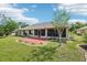 Lovely backyard showcases a brick patio, lush lawn, mature landscaping and screened patio at 179 Patrice Hope St, Leesburg, FL 34748