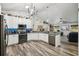 Open kitchen with granite countertops, stainless appliances, white cabinets, dark sink and view of living room at 179 Patrice Hope St, Leesburg, FL 34748
