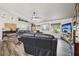 Comfortable living room featuring leather sofas, ceiling fan and decoratively-shelved vaulted ceilings at 179 Patrice Hope St, Leesburg, FL 34748